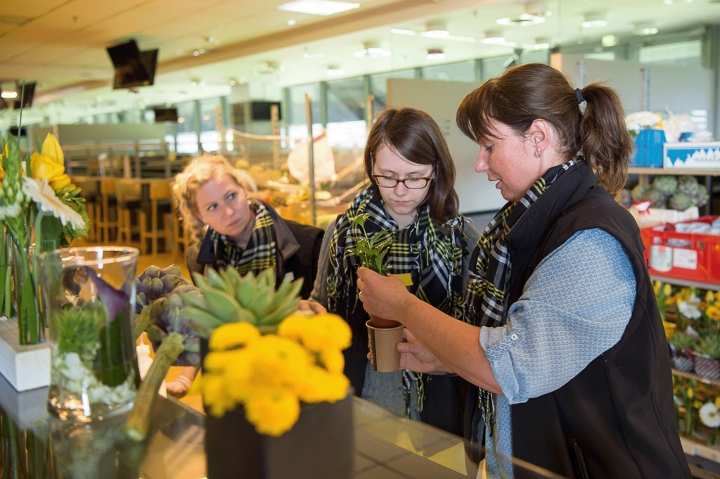 Drei Mitarbeiterinnen von Moderne Floristik Steinbrecher arrangieren Blumen