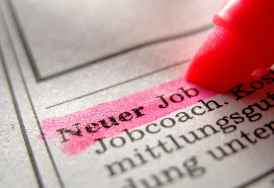Die Textpassage 'Neuer Job' in einer Zeitung wird mit pinkem Textmarker hervorgehoben.
